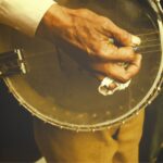 Close up of hand plucking banjo